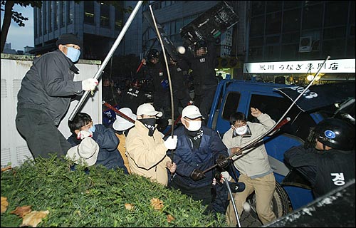 서울시청 뒷골목에서 쇠파이프를 든 노동자 사수대들이 경찰에 포위당해 있다. 